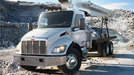 Peterbilt Model 548 Medium Duty Silver Truck with White Crane among Concrete Debris Field - Thumbnail